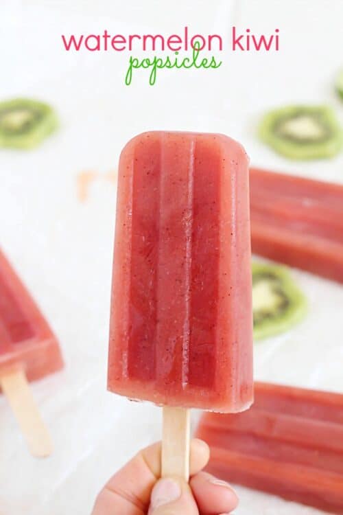 A Watermelon Kiwi Popsicle with Kiwi Slices and More Popsicles in the Background