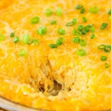 A Bowl of Warm Buffalo Chicken Dip with a Sizeable Scoop Removed