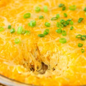 A Bowl of Warm Buffalo Chicken Dip with a Sizeable Scoop Removed