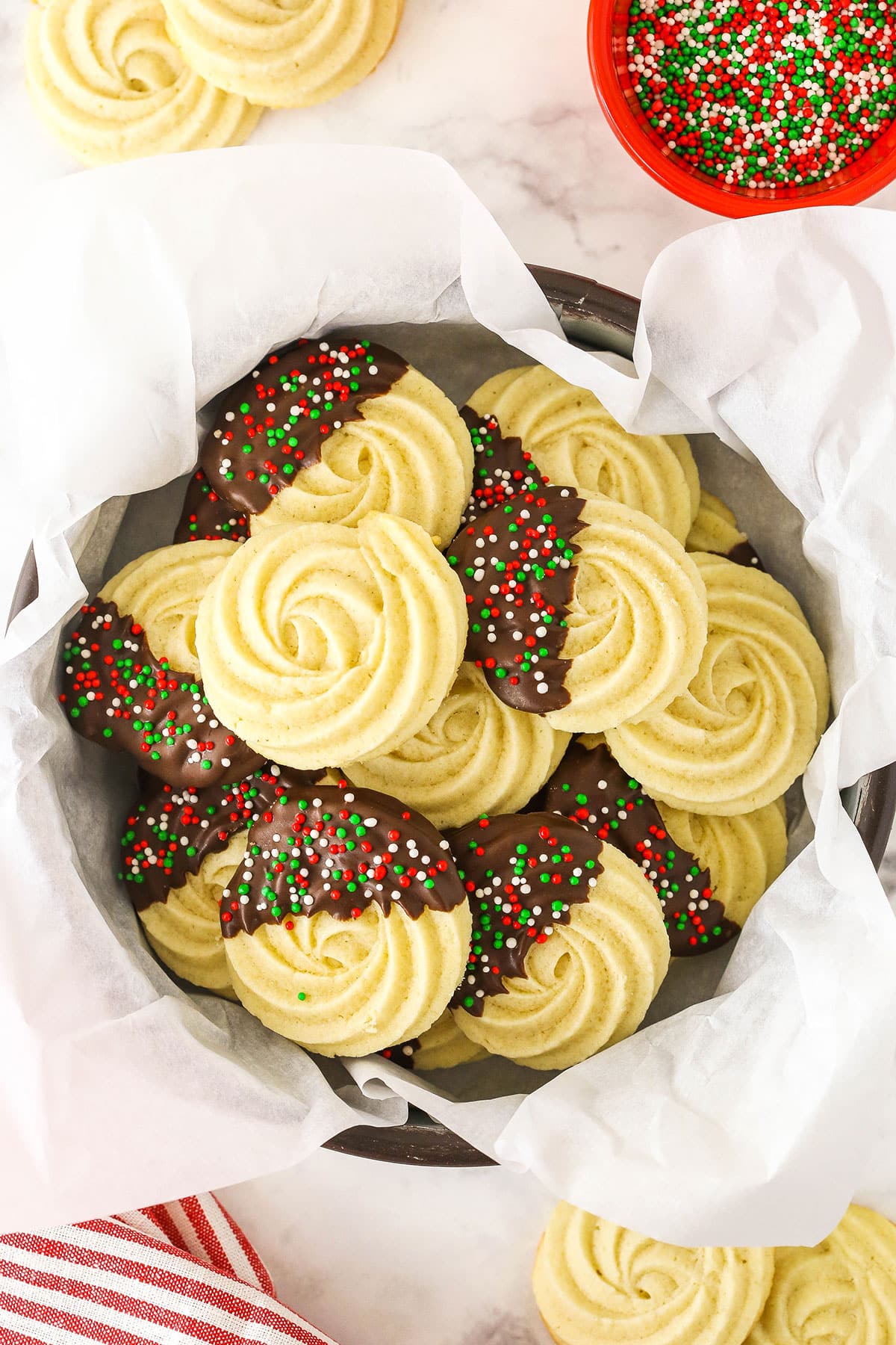 A tin filled with butter cookies and lined with parchment paper.