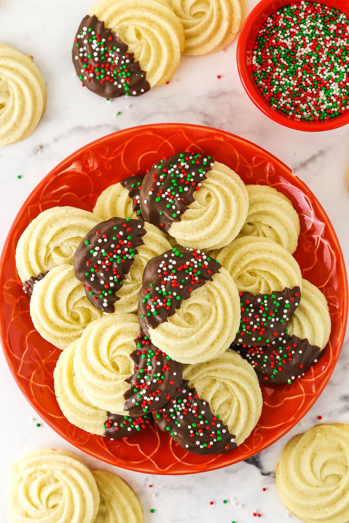 A plate full of butter cookies on a white marble counter.