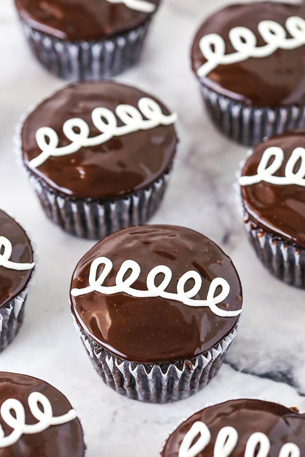 Eight Marshmallow-Filled Chocolate Cupcakes on a Marble Counter.