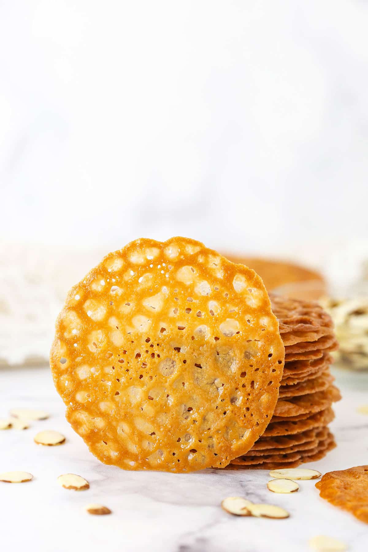 Lace Cookies A Single Lace Cookie Propped Up Against a Stack of More Cookies