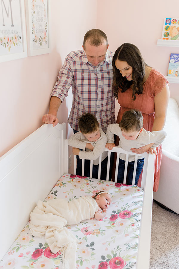 The four of us looking at McKenzie in her crib