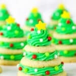 Stacked sugar cookie Christmas trees on marble table.