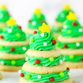 Stacked sugar cookie Christmas trees on marble table.