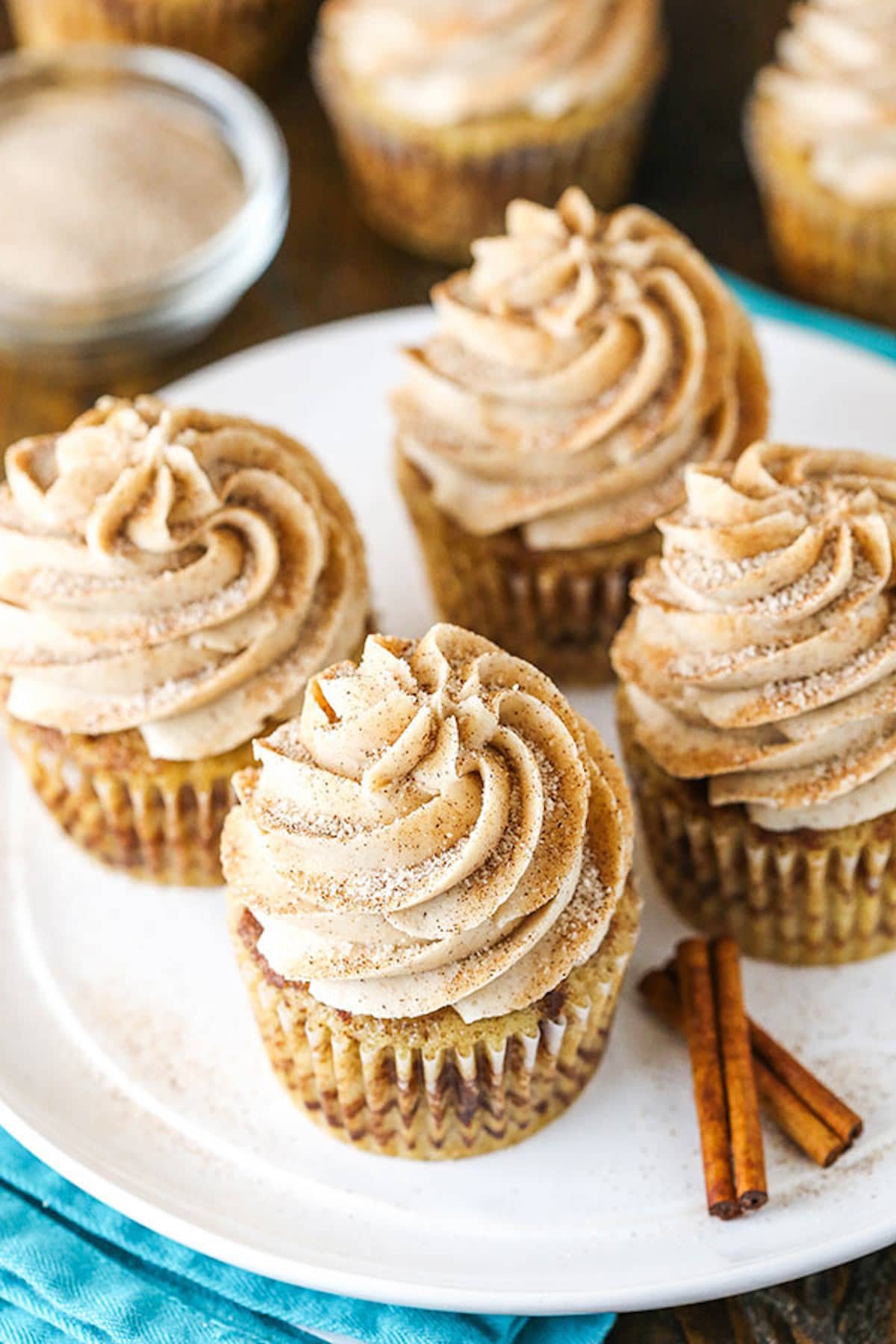 Four Cinnamon Sugar Cupcakes on a Plate with Two Mini Cinnamon Sticks