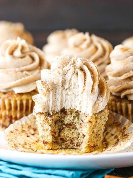 A Cinnamon Roll Cupcake on a Plate with One Bite Taken Out