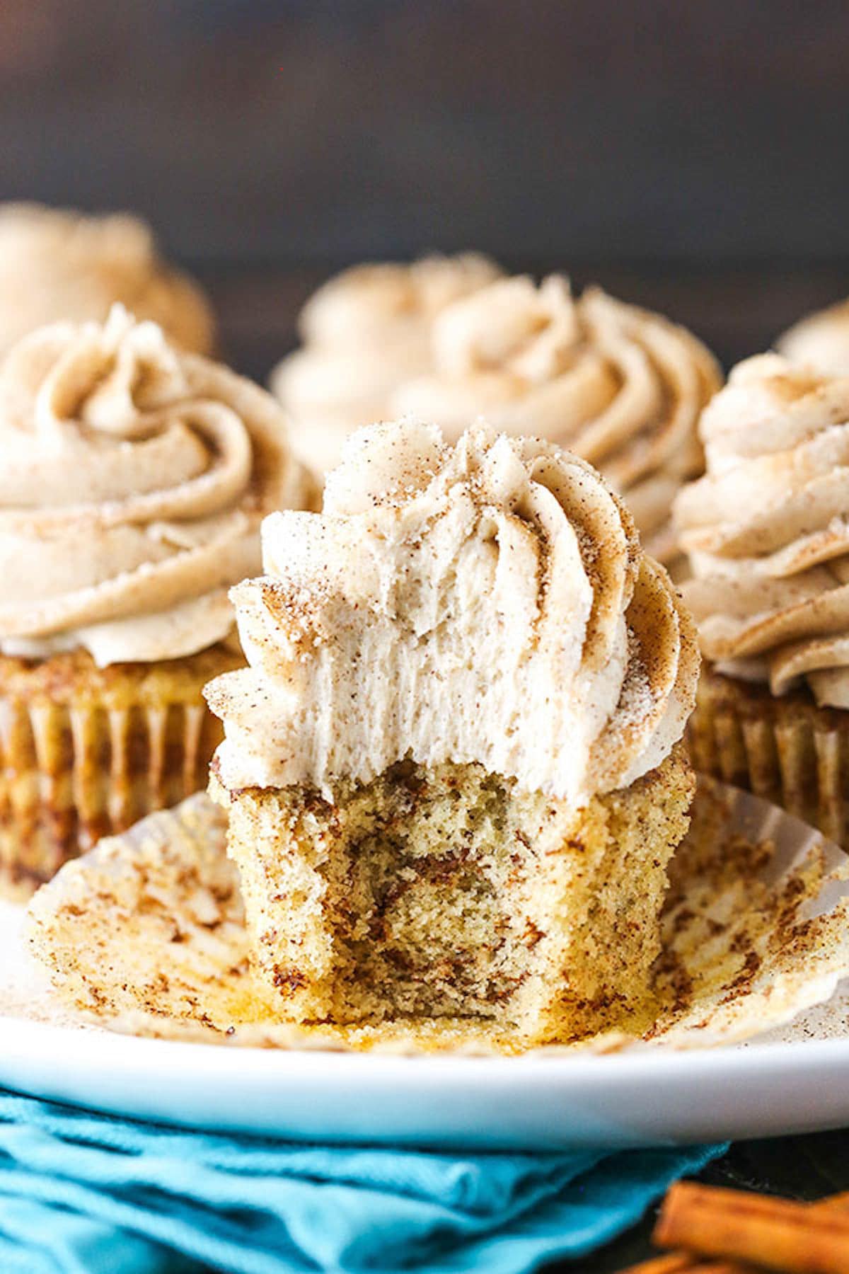 A Cinnamon Roll Cupcake on a Plate with One Bite Taken Out