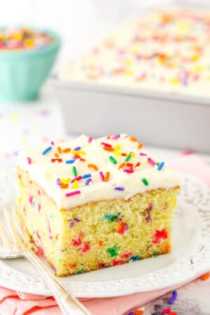 A Slice of Confetti Cake on a Plate with a Lace-Patterned Border