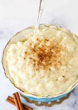 Warm Rice Pudding in a Teal Bowl with a Silver Spoon.