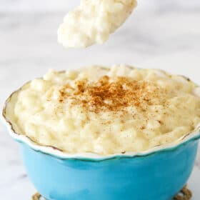 A Spoonful of Rice Pudding Hovering Over a Full Bowl.