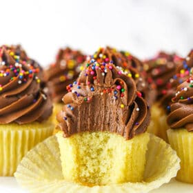 An Unwrapped Yellow Cupcake with a Bite Taken Out