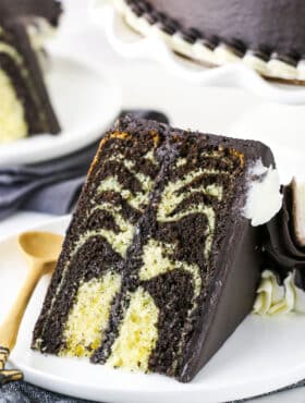 A Piece of Zebra Cake on a Plate with a Wooden Spoon