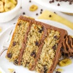 slice of banana chocolate chip cake on white plate with yellow napkin