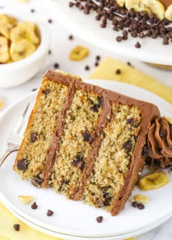 slice of banana chocolate chip cake on white plate with yellow napkin