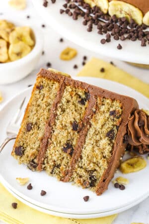 slice of banana chocolate chip cake on white plate with yellow napkin