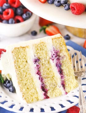 A Piece of Chantilly Layer Cake on a Plate with Fresh Berries