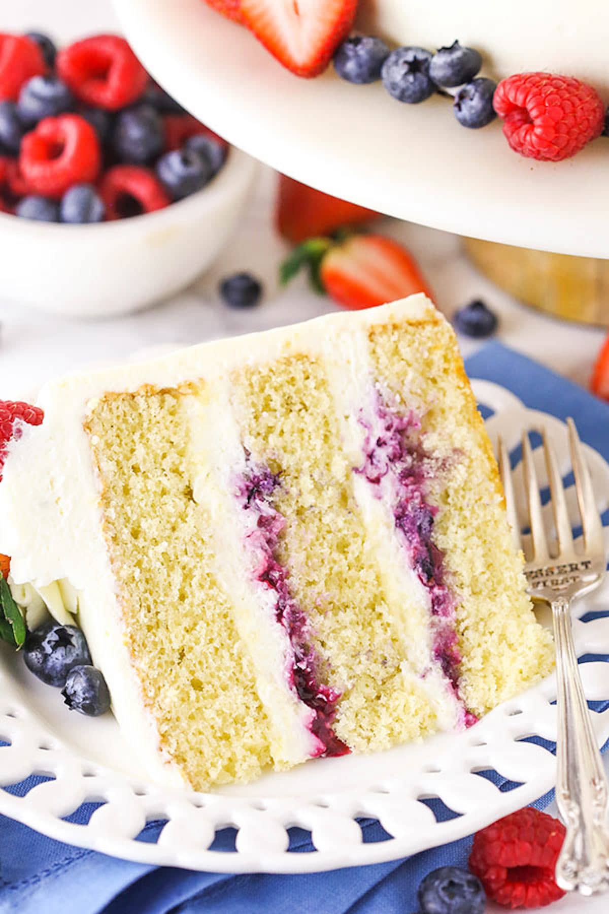A Piece of Chantilly Layer Cake on a Plate with Fresh Berries