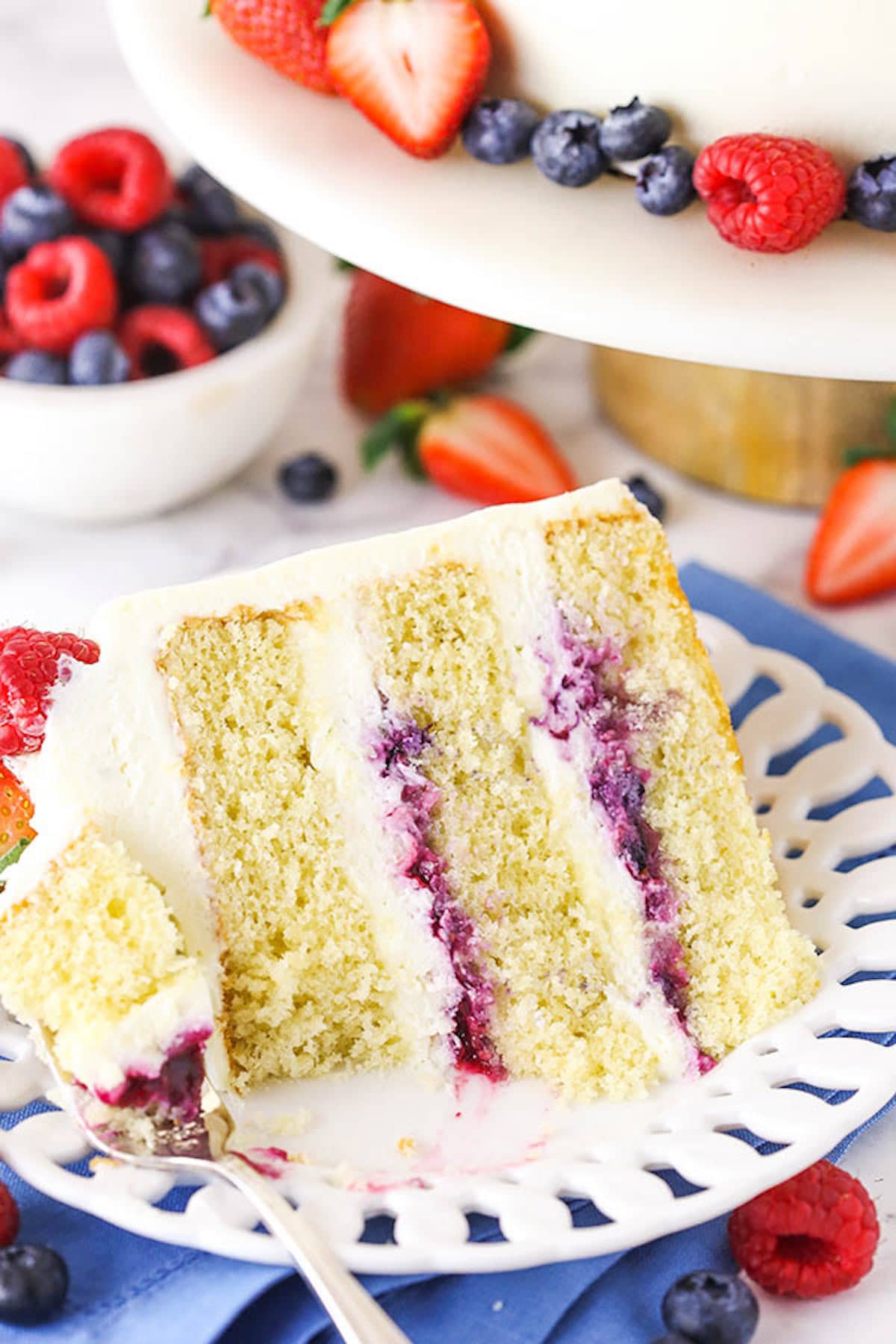 Berry Chantilly Cake A Slice of Berry Chantilly Cake with One Bite on a Fork