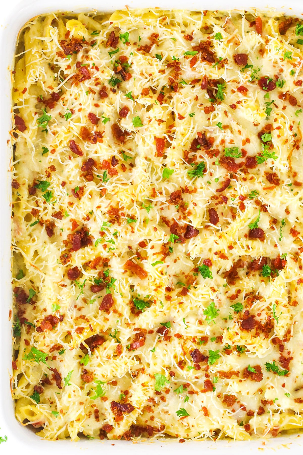 Overhead image of entire chicken bacon ranch casserole with shredded cheese and bacon bits on top.