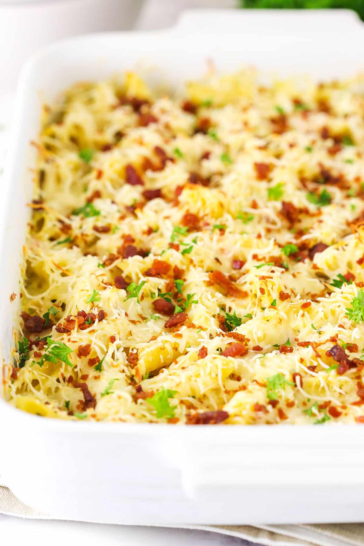 Casserole in the baking dish. Topped with cheese and bacon bits.