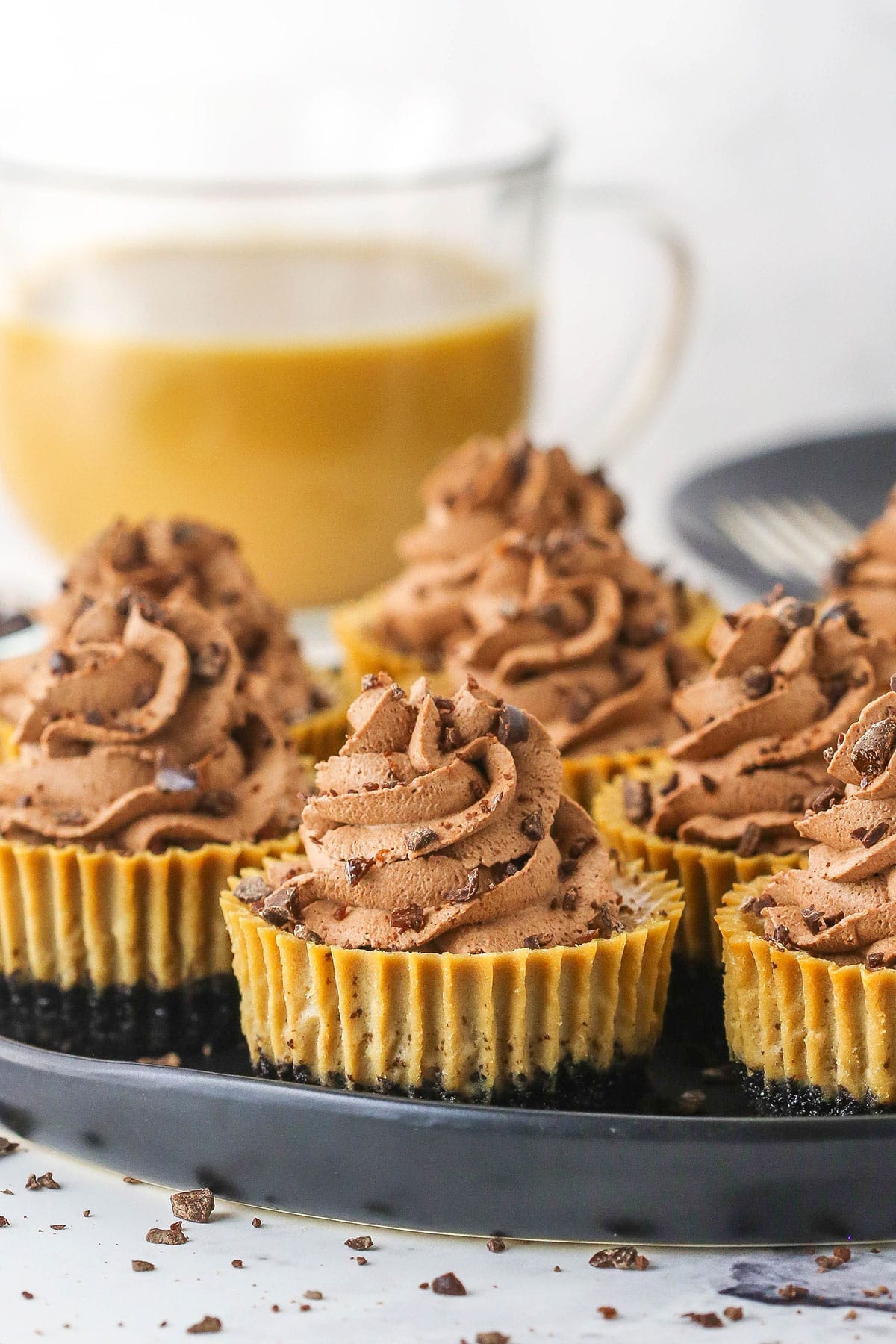 Eight mini coffee cheesecakes on a black serving tray. 