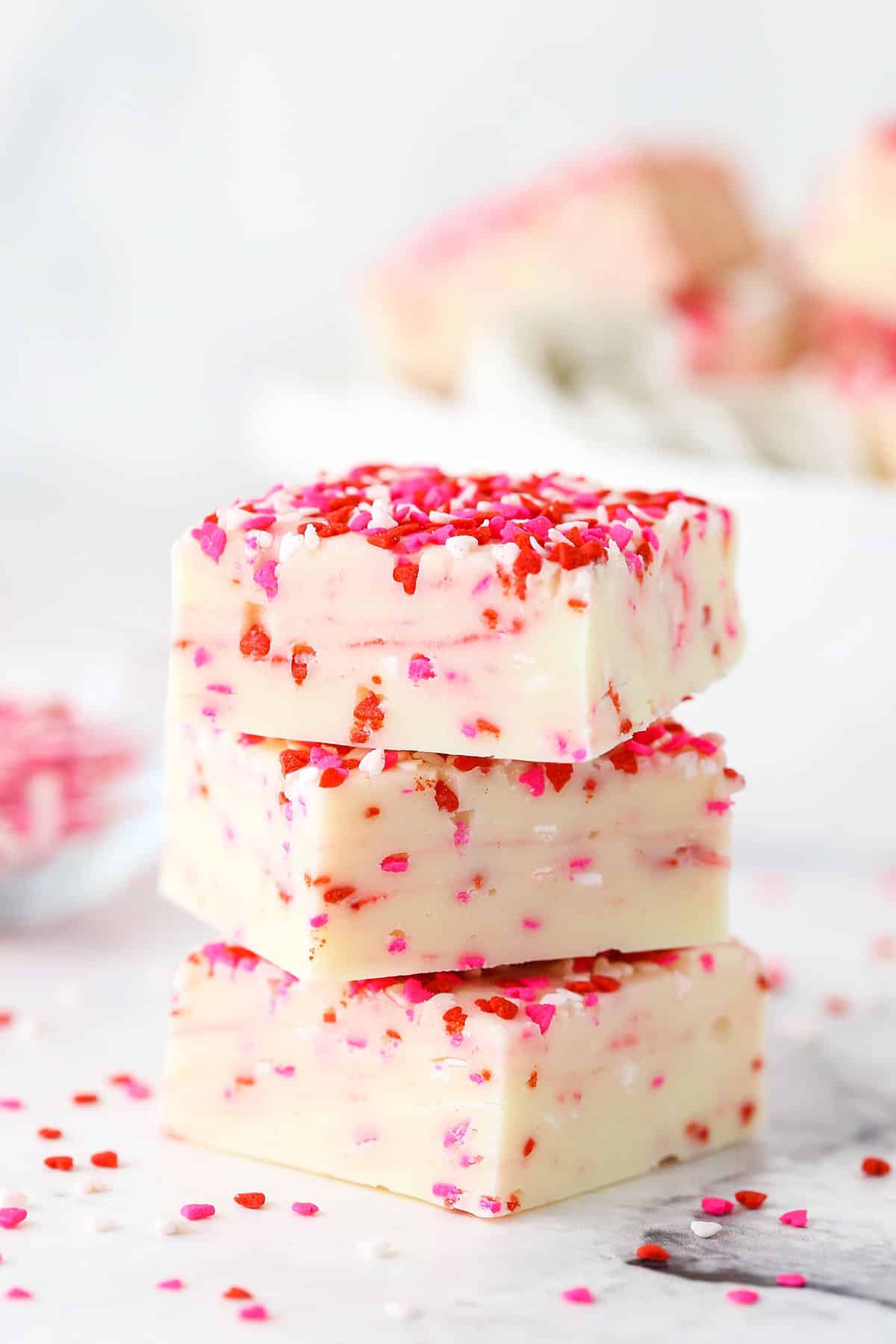 Side view of three squares of Valentine's Day fudge stacked on top of each other. 