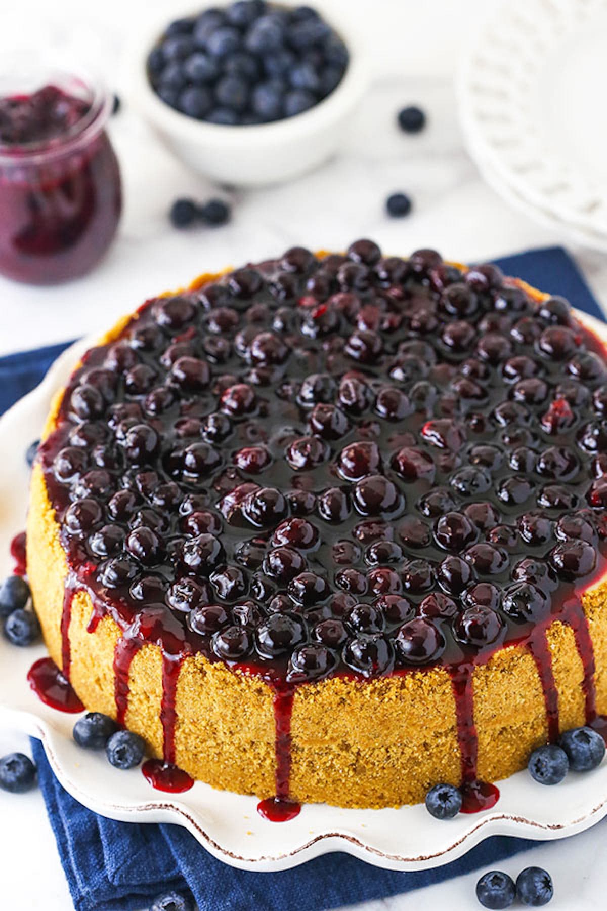 The Top View of a Blueberry Cheesecake with Sauce Dripping Down the Sides of the Cake