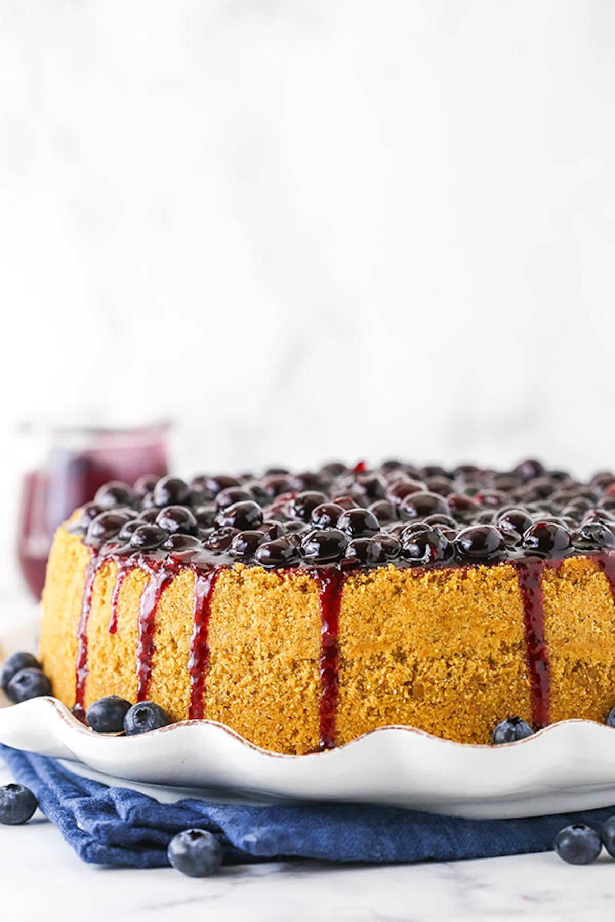 A Baked Blueberry Cheesecake on a Serving Plate with a Blue Napkin Underneath