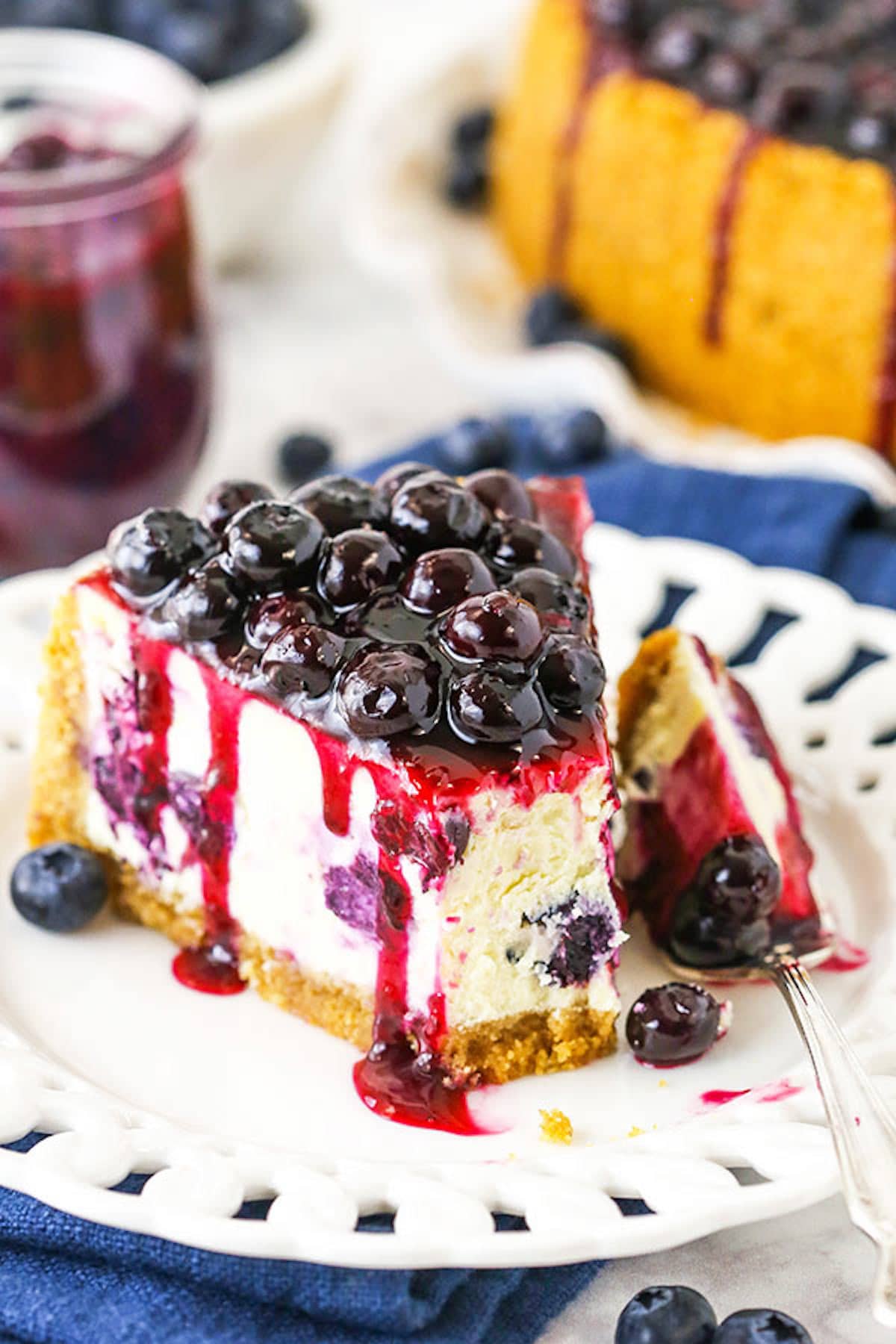 A Slice of Blueberry Cheesecake on a Plate with One Bite on a Fork
