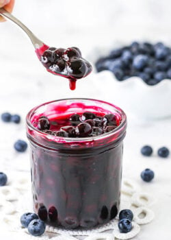 A Spoon Scooping Out Some Homemade Blueberry Sauce From a Jar