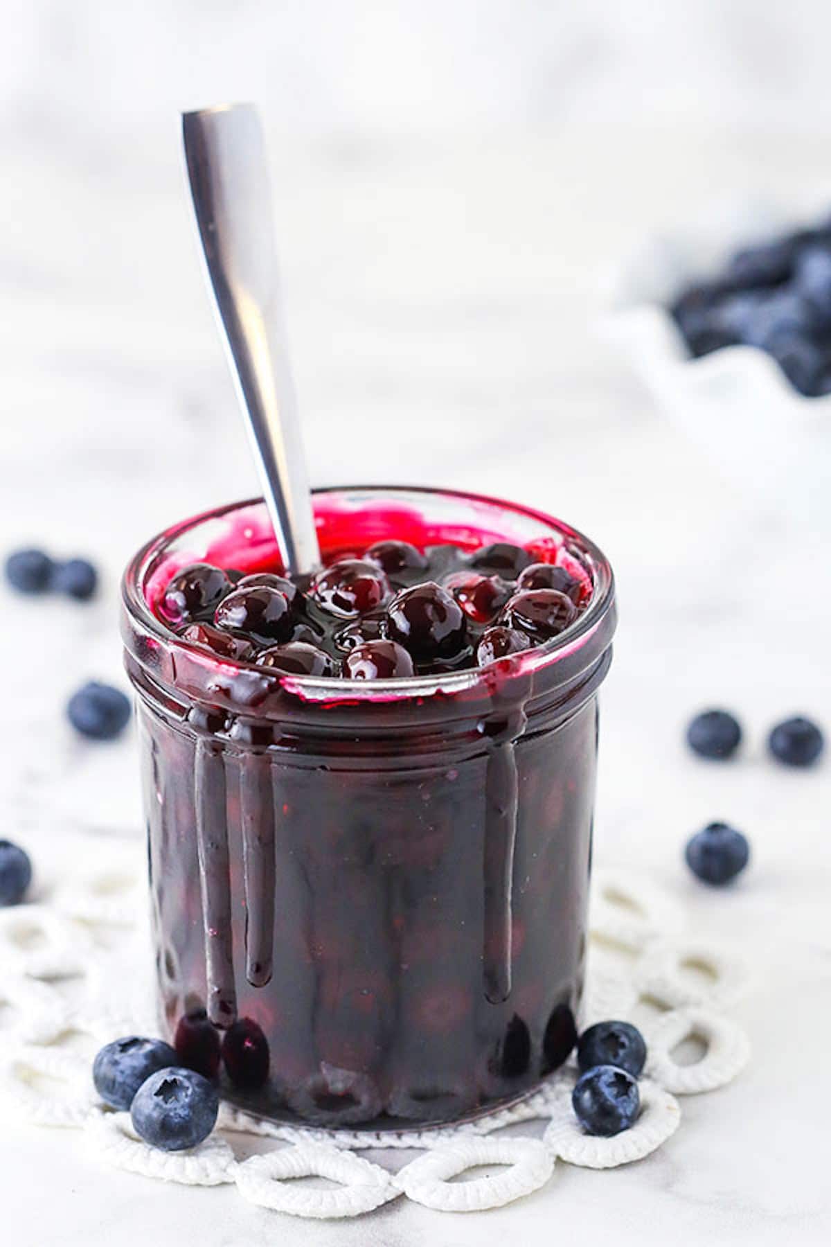 A Jar of Blueberry Sauce with a Metal Spoon Inside
