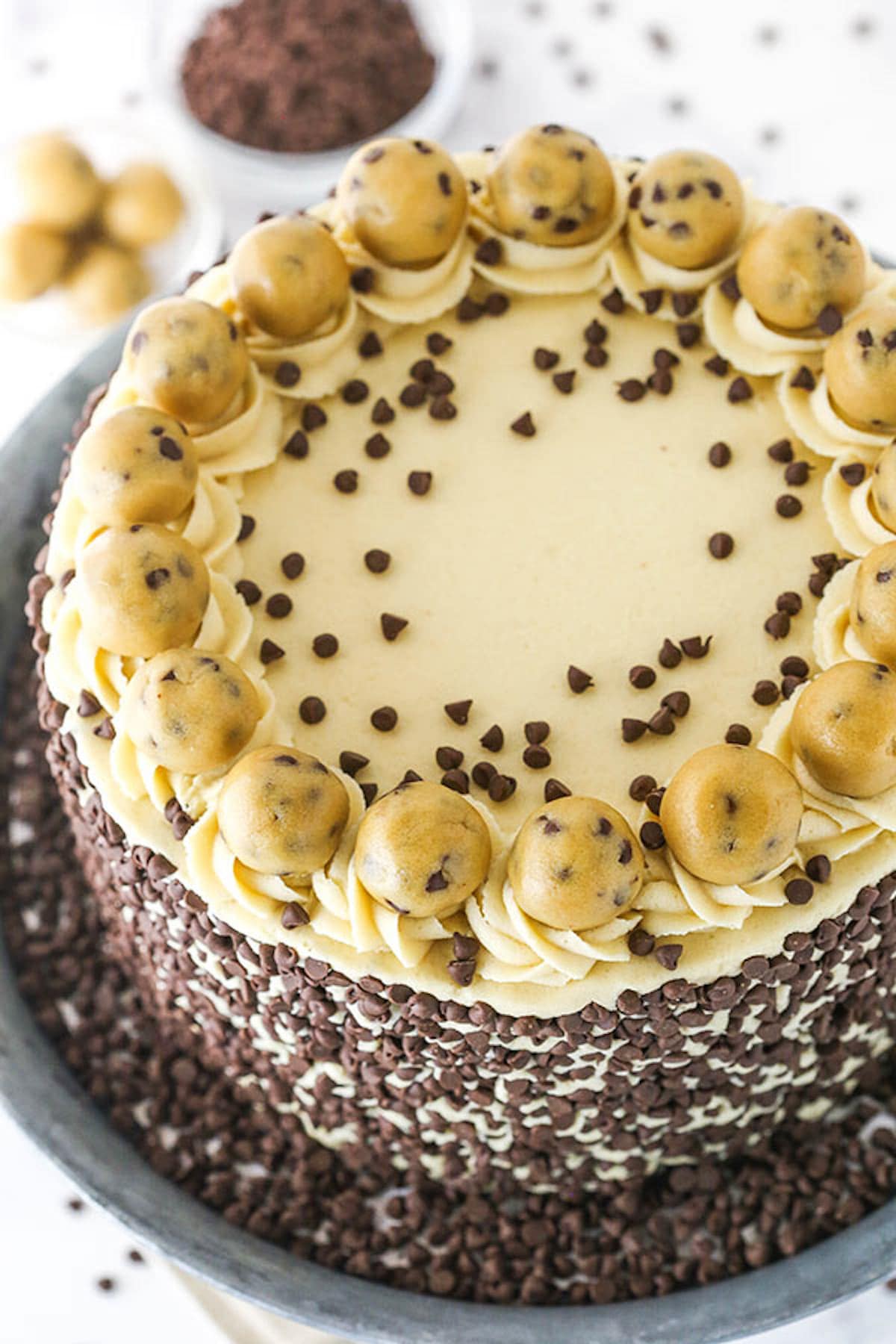 A Cookie Dough Layer Cake with Cookie Dough Frosting, Chocolate Chips and Balls of Dough on Top