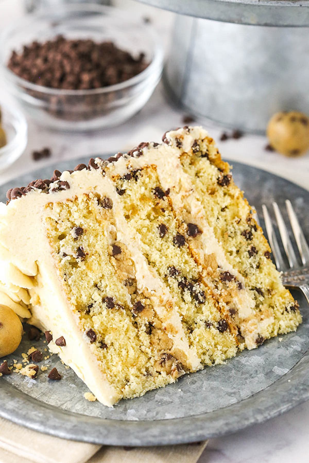 A Piece of Chocolate Chip Cake on a Plate in Front of a Bowl of Mini Chocolate Chips