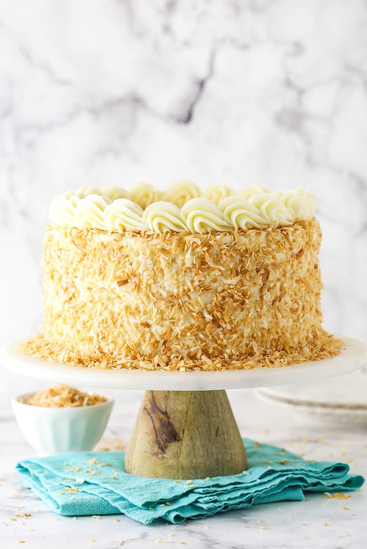 full image of coconut custard cake on wood and marble cake stand