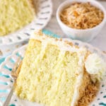 slice of coconut custard cake on a white plate with teal napkin