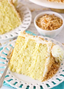 slice of coconut custard cake on a white plate with teal napkin