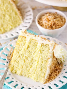 slice of coconut custard cake on a white plate with teal napkin