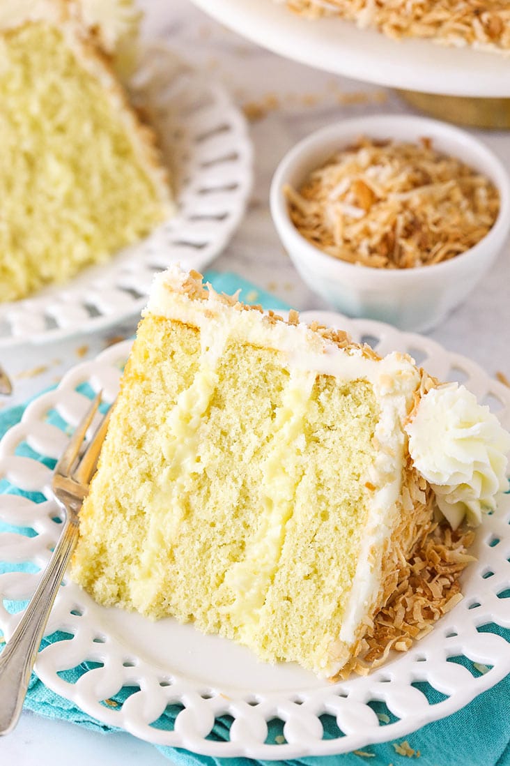 slice of coconut custard cake on a white plate with teal napkin