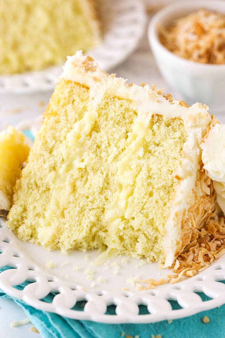 coconut custard cake slice with a bite taken on teal napkin