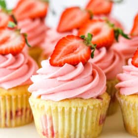 close up of strawberry cupcakes on marble cake stand