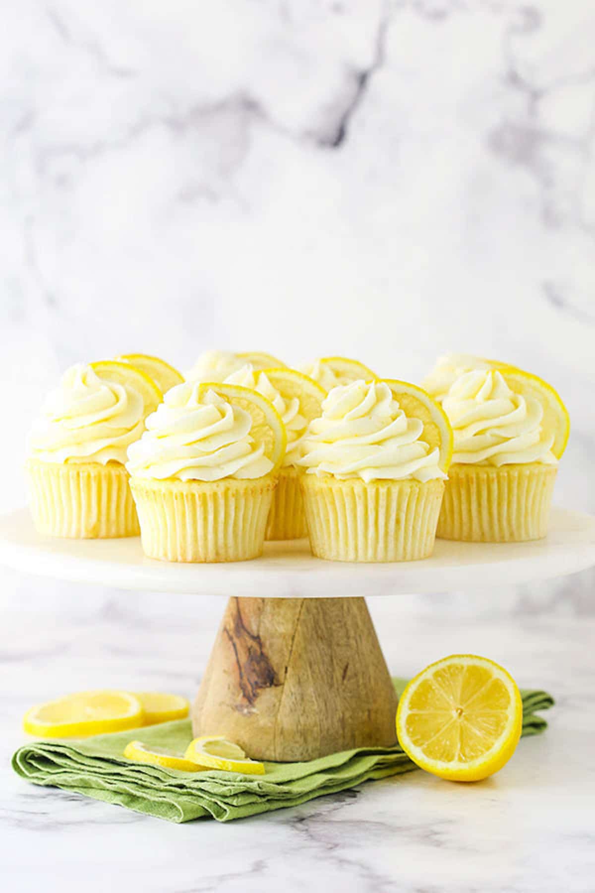 A Cake Stand Full of Lemon Cupcakes in Front of a Marble Backdrop