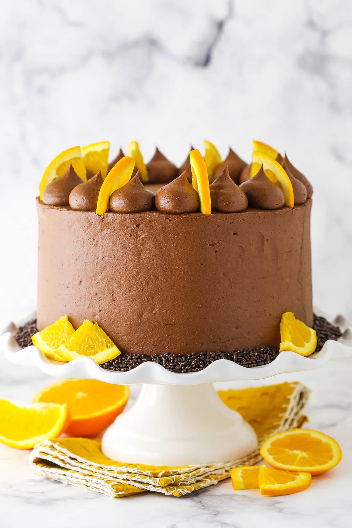 full cake on a white cake stand with a yellow napkin