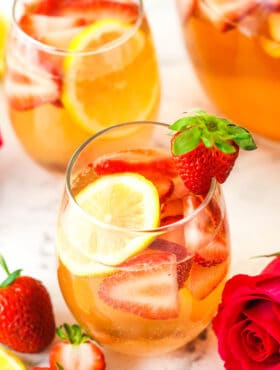A glass of Rosewater Rosé Sangria garnished with a fresh strawberry