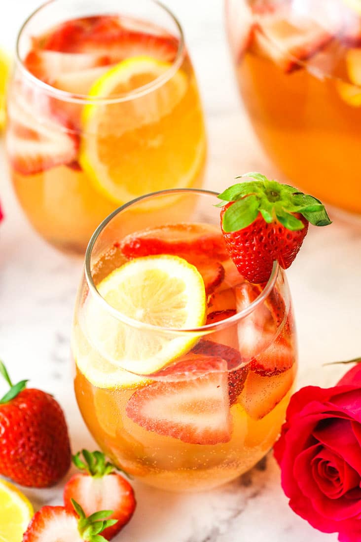 A glass of Rosewater Rosé Sangria garnished with a fresh strawberry