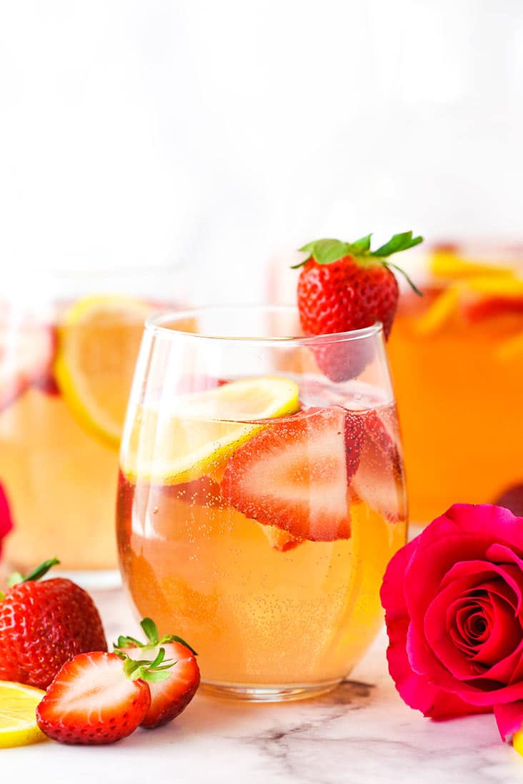 3 glasses of rosewater sangria, garnished with a fresh streberry and rose. 