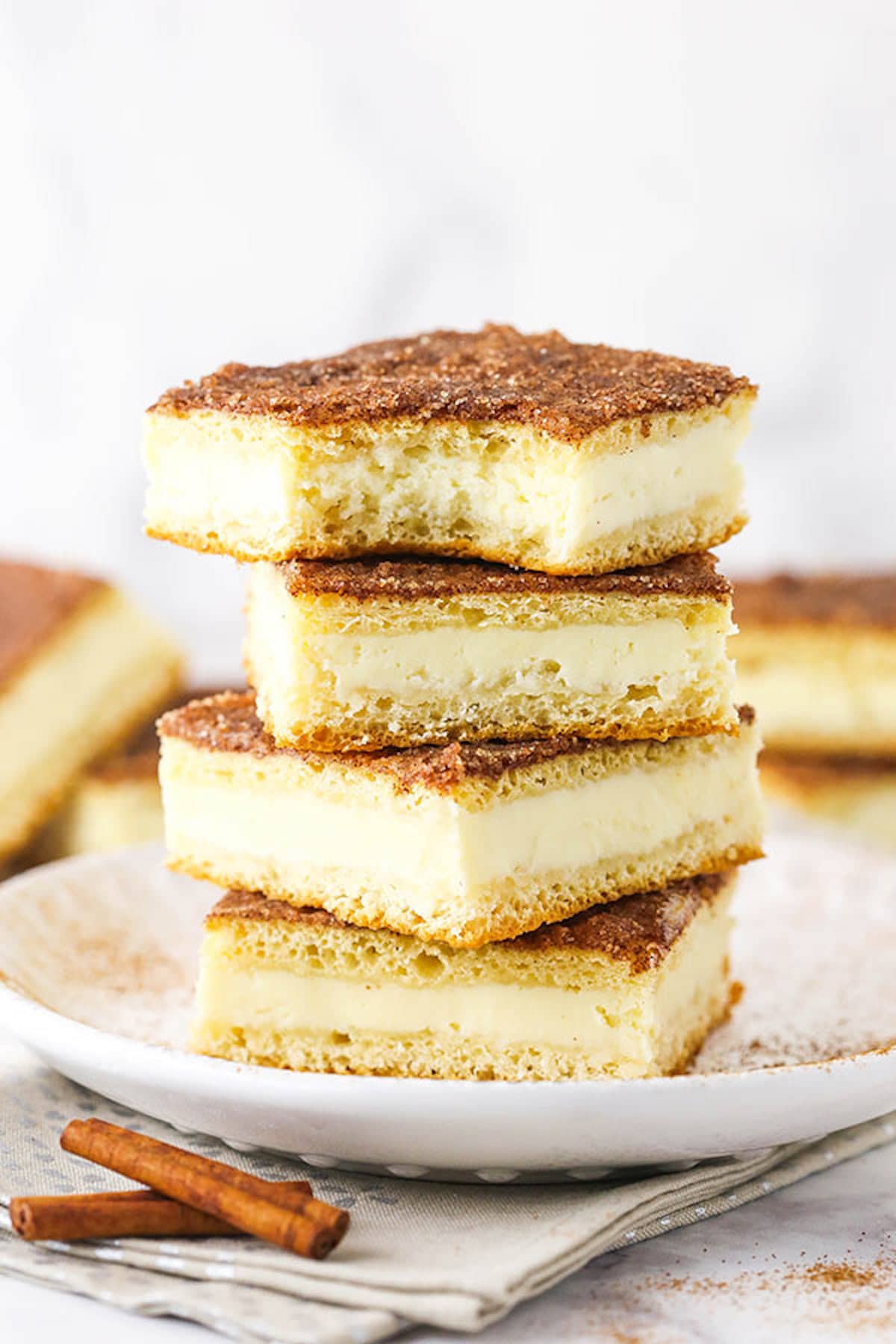 A Stack of Four Sopapilla Cheesecake Bars on a Plate