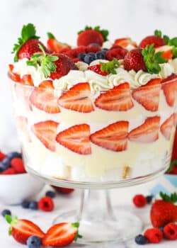 Triple Berry Trifle in clear trifle dish with berries around the bottom