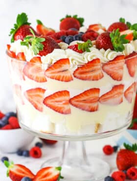 Triple Berry Trifle in clear trifle dish with berries around the bottom